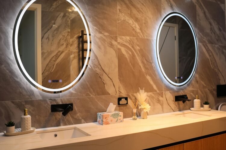 Elegant bathroom interior featuring a double vanity with circular backlit mirrors, sleek design.