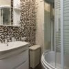 Stylish bathroom featuring mosaic tiles, round shower, and modern fixtures.