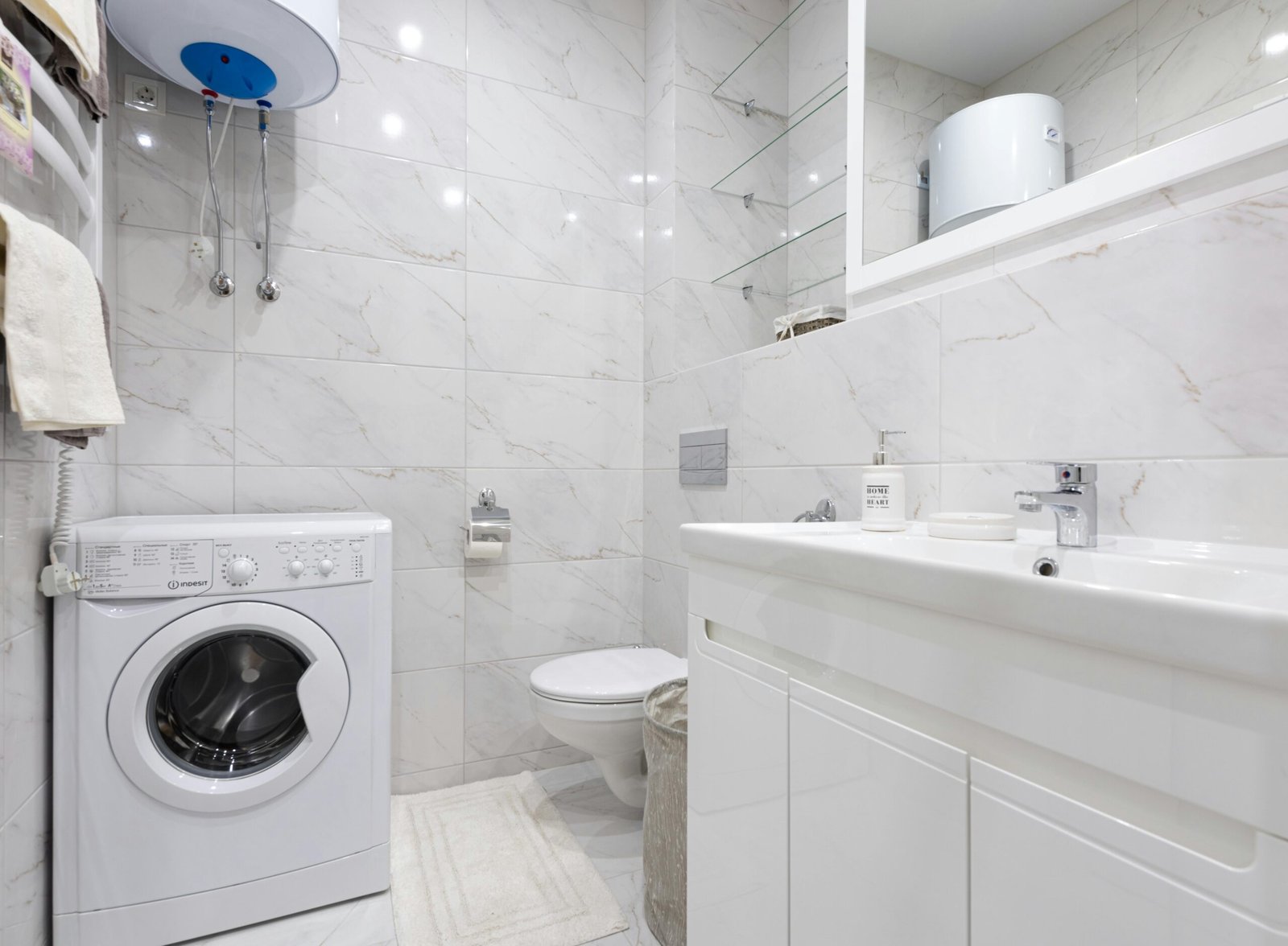Bright minimalist bathroom featuring a washing machine and modern fixtures.